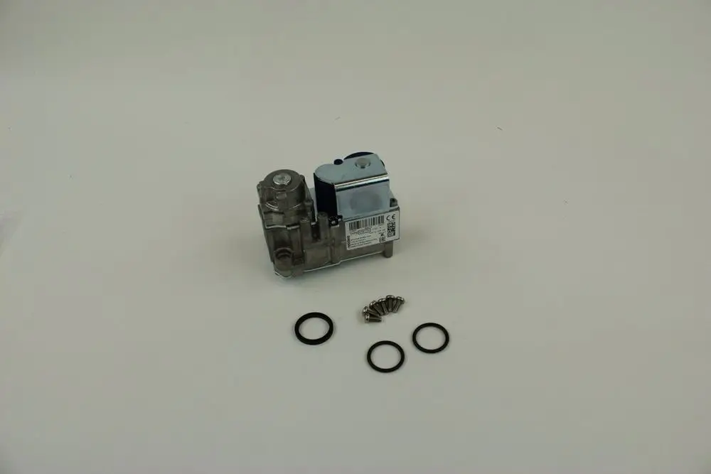BOSCH Gasarmatur mit silberner Oberfläche und einem Kabelanschluss, daneben zwei O-Ringe und mehrere Schrauben auf einem weißen Hintergrund.
